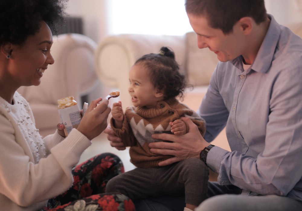 Dad holding a baby and mom feeding the baby